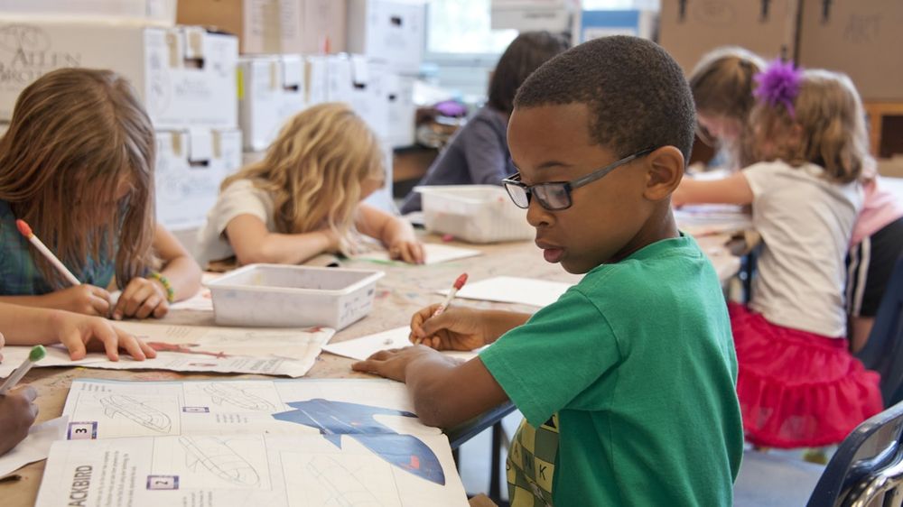Children working together at desks in a classroom at the start of the school year
